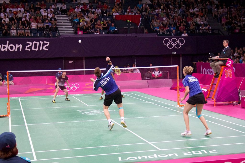 players playing doubles game in badminton court in Olympics